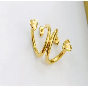 Detailed close-up of shiny gold-plated earrings featuring elegant heart-shaped ends.