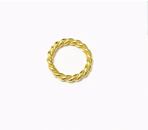 Close-up detail shot of the elegant gold twisted rope ring showing fine metallic texture.