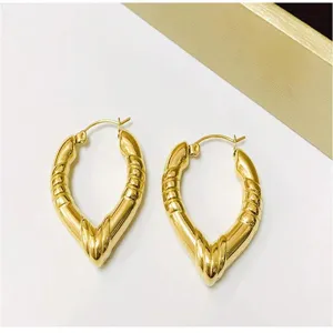 Close-up detail shot of retro stainless steel hollow bamboo pattern heart hoop earrings.