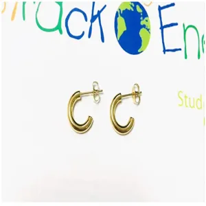 Detailed shot of thick gold C-shaped hoop earrings, trendy minimalist jewelry design for daily wear.