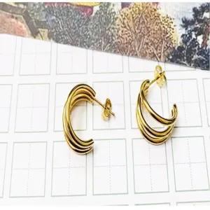 Close-up detail of mini triple C-shape hoop earrings in 18k gold plated stainless steel.