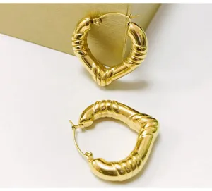 Detailed view of gold chunky heart hoop earrings with unique ribbed texture and secure clasp.