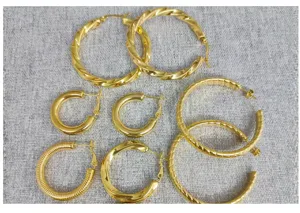 Detail view of multi-style stainless steel 18K gold plated twisted and smooth hoop earrings.
