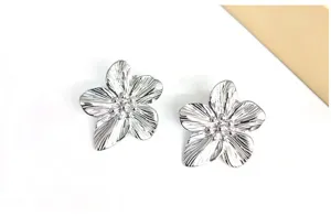 Silver five-petal flower stud earrings, elegant metallic floral design for daily wear.