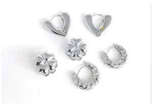 Stainless steel geometric earrings set, closeup of silver huggie hoops and clover studs.