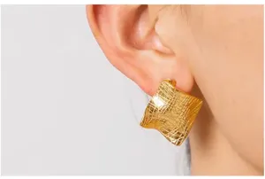 Textured gold square geometric earring close-up, premium 18k metal detail fashion jewelry.