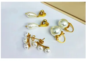 Vista detallada de pendientes de aro y corazón de perlas en acero inoxidable oro 18k.
