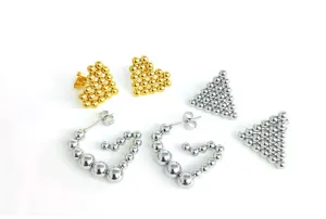 Stainless steel beaded heart and triangle stud and hoop earrings detail view, silver and gold metal.