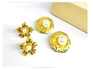 Detailed closeup view of stylish gold floral and textured round pearl stud earrings.