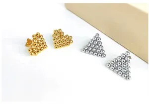 Detail view of metallic beaded heart and triangle earrings, showcasing unique geometric styles.