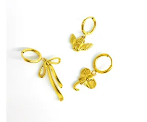 Detailed close-up of 18k gold plated stainless steel bow angel elephant hoop earrings set.