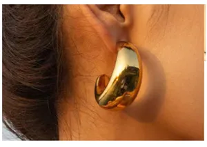 Thick chunky gold C-shape hoop earrings, statement polished metal ear jewelry for women daily wear.