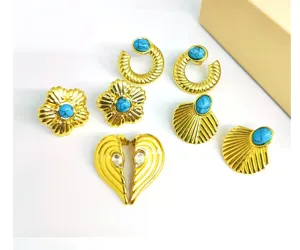 Close-up detail shot of vintage gold-plated statement earrings featuring turquoise stones.