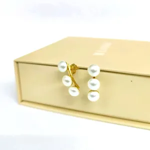 Elegantes pendientes de perlas de acero dorado, joyería minimalista moderna de lujo.