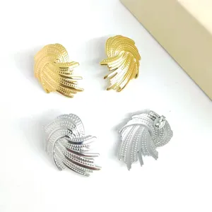 Chic metal stud earrings featuring unique swirled wing design with hammered texture, gold and silver.