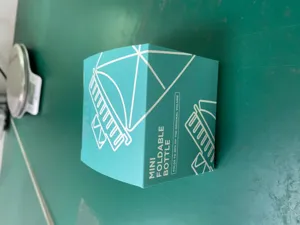 Mini collapsible silicone water bottle packaging box detail view, portable outdoor travel cup.