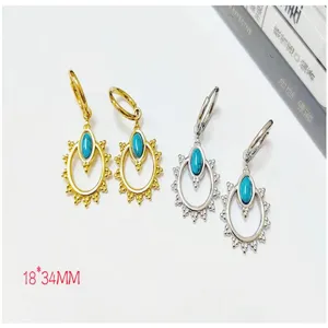 Detail view of turquoise sunburst hoop earrings, 18K gold and silver stainless steel.