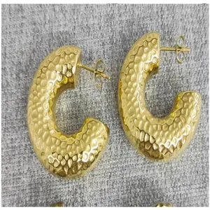 Close-up view of textured gold hoop earrings, showcasing the unique hammered surface finish.