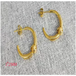 Close-up detail of the gold stainless steel twisted knot hoop earrings showcasing fine texture.