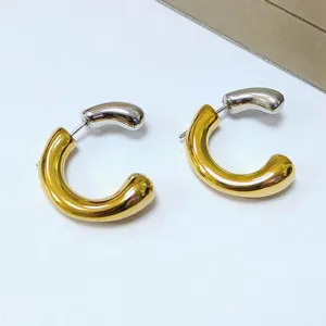 Chunky stainless steel two-tone hoop earrings, modern gold and silver minimalist chic jewelry.