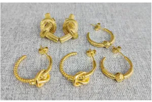 Detailed view of fashionable gold tone knot hoop and stud earrings with unique twist texture.