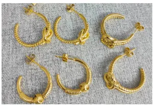 Detailed shot of stainless steel 18K gold plated hoop earrings with stylish knot and braided design.