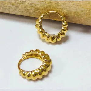 Élégantes boucles d'oreilles créoles dorées épaisses au design géométrique texturé unique.