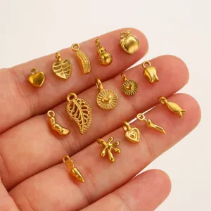 Pendentifs mini breloques en acier inoxydable doré détail gros plan pour fabrication bijoux.