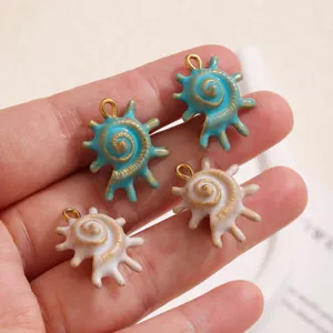 Close-up of cute enamel seashell pendants with gold details, perfect for DIY jewelry making.