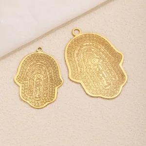 Detailaufnahme des goldenen Hamsa Hand Anhängers mit filigraner arabischer Kalligraphie Gravur.