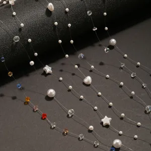 Gros plan détaillé de chaînes de perles en fil invisible transparent avec des perles et cristaux.