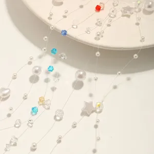 Gros plan detail accessoire de chaine de perles et de cristal faits main avec pendentifs.