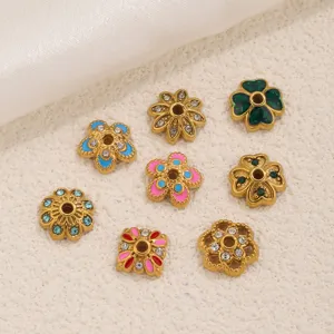 Detailaufnahme von bunten emaillierten Blumenperlenkappen als DIY Schmuckabstandshalter.