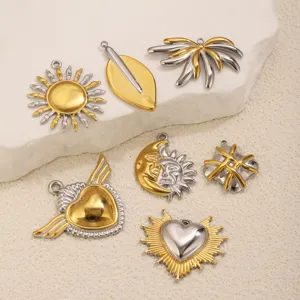 Gros plan sur des pendentifs de bijoux vintage en acier inoxydable bicolore pour le bricolage.