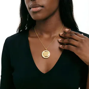 Close-up detail shot of the stainless steel rhinestone round pendant necklace worn elegantly.