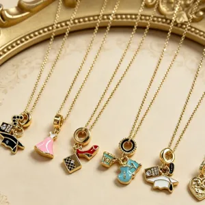 Vergulde delicate ketting met meerdere kleurrijke geëmailleerde hangers zoals jurk en schoenen.