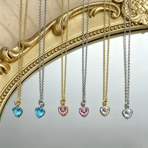 Vue détaillée de colliers pendentifs cœur doux avec chaînes or et argent et cristaux colorés.