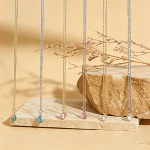 Vue détaillée de délicats colliers pendentifs en cristal en forme de cœur sur chaînes fines.