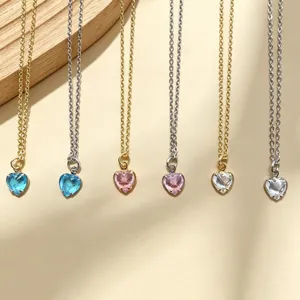 Gros plan détail de colliers pendentifs en cristal de cœur délicat en or et argent avec couleurs.