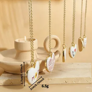 Detailed view of trendy European and American style gold chain necklace with white heart pendant.