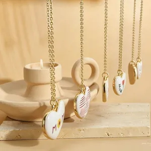 Fashion gold chain necklace with white heart pendant, elegant and minimalist jewelry design.