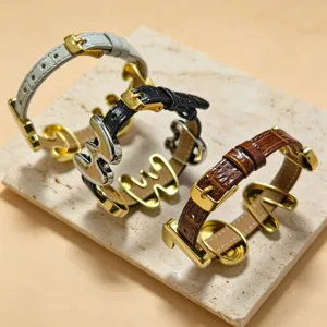 Detailed close-up of retro leather strap bracelets with metal letter charms, stylish DIY accessories.