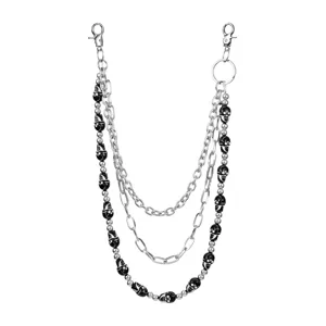 Detailed view of punk style triple layer pants chain with silver metal links and black skulls.
