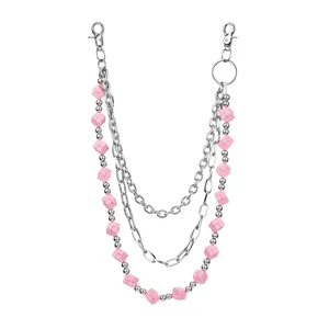 Detailed shot of three-layer pink cube block and silver metal chain pants accessory.