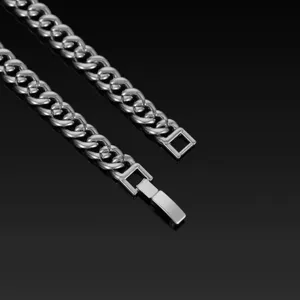 Close-up of the silver cuban link chain clasp and interlocking links, showing fine metal details.