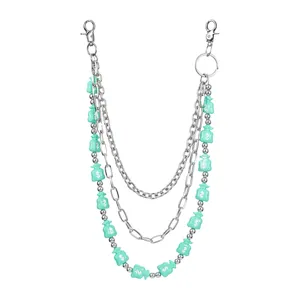 Detailed view of the multi-layer metal pants chain with mint green money bag charms.