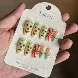 Handcrafted almond press-on nails featuring cute clown face and candy design for party.