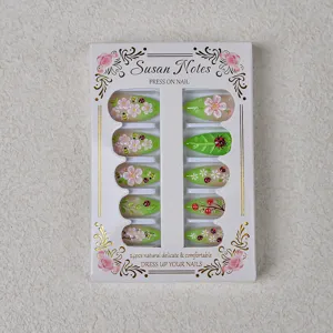 Vue détaillée de 24 faux ongles avec de jolies fleurs, feuilles et motifs de coccinelles.