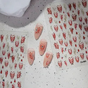 Close-up detail of 3D jelly red butterfly nail art stickers and press-on nail samples.
