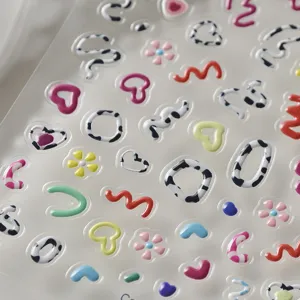 Close-up van 3D enbossed gel nagelstickers met schattige hartjes en leuke bloemmotieven.